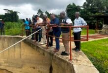Mr Mutawakilu (front row fourth from right) and other officials at one of the water treatment site