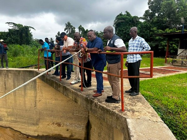 Mr Mutawakilu (front row fourth from right) and other officials at one of the water treatment site