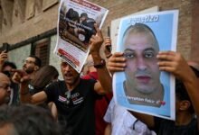 A protester holds a flyer during a protest following the death of Abderrahim Fakir in Bologna, Italy