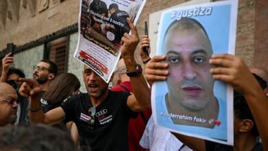 A protester holds a flyer during a protest following the death of Abderrahim Fakir in Bologna, Italy