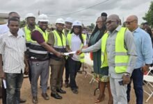Ms Nongo (second from right) being assisted to present the document to the contractor