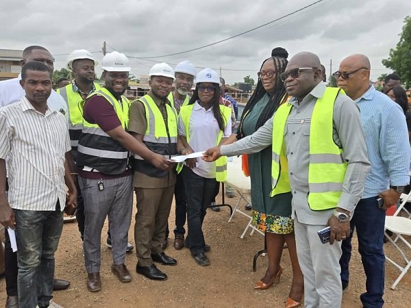 Ms Nongo (second from right) being assisted to present the document to the contractor