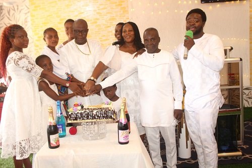 Apostle Eric Botchwey (third from left) and wife jointly cutting the birthday cake during the sunday church service