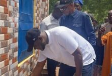Mahama drawing the water with cup to inaugurate the mechanised borehole