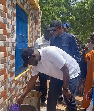 Mahama drawing the water with cup to inaugurate the mechanised borehole
