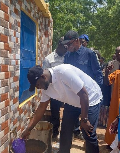 Mahama drawing the water with cup to inaugurate the mechanised borehole