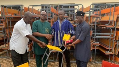 Mr Moabalyn (in smock) presenting the desks to GES officials