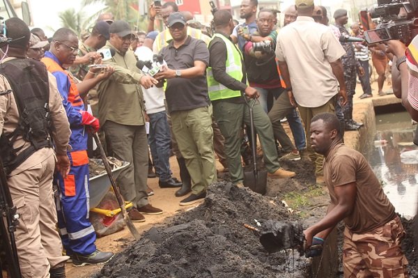 President Mahama pointing out extent of damage caused by the choked gutter at Tse Addo. Photo. Ebo Gorman