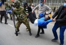 Kenyan police officers arrest a protester,