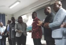 Mr George (third from right) presenting the laptops to Professor Amfo