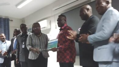 Mr George (third from right) presenting the laptops to Professor Amfo