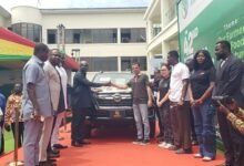 Mr Opoku (fourth from left) receiving the keys to the pickup from Mr Raab