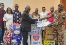 Evangelist Boakye (left) presenting some of the items to Sgt Seidu