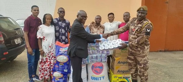 Evangelist Boakye (left) presenting some of the items to Sgt Seidu
