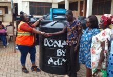 Ms Nongo (left) presenting a Polytank to beneficiary and his family