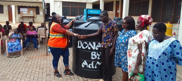 Ms Nongo (left) presenting a Polytank to beneficiary and his family