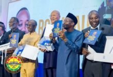 Mr Bagbin (second from right) being assisted by other dignitaries to launch the book