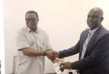 Mr Afriyie Ankrah (left) presenting the money to Dr Yakubu Seidu Adam