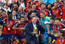 Spain coach Luis De La Fuente celebrates with the World Cup trophy alongside his players