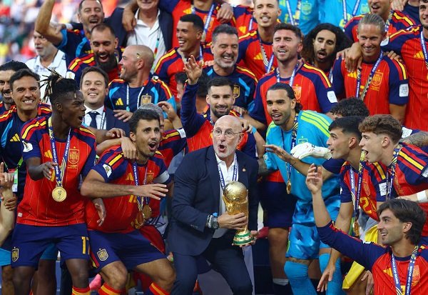 Spain coach Luis De La Fuente celebrates with the World Cup trophy alongside his players