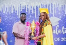 Dr Atta Kumah (left) presenting the trophy to Ms Caromon K. Appiah at the ceremony
