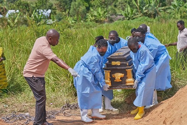The coffin of an Ebola victim is carried to a gravesite