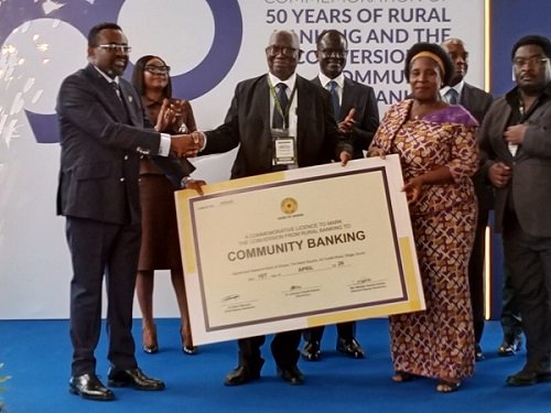 Dr Asiama (left) presenting Community Bank License to a representative of La Commuinity Bank ( second from right)