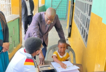 Mr Iddrisu (middle) interacting with one of the pupils at St Peter's RC Basic Osu.jpg