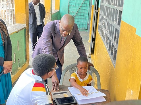 Mr Iddrisu (middle) interacting with one of the pupils at St Peter's RC Basic Osu.jpg