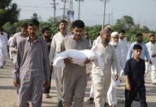 A man carries one of the body of a newborn baby for burial