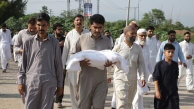 A man carries one of the body of a newborn baby for burial