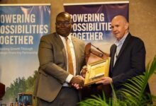 Mr Hill (right) and an official of Access Bank exchanging the signed document