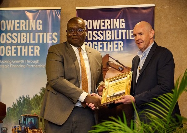 Mr Hill (right) and an official of Access Bank exchanging the signed document