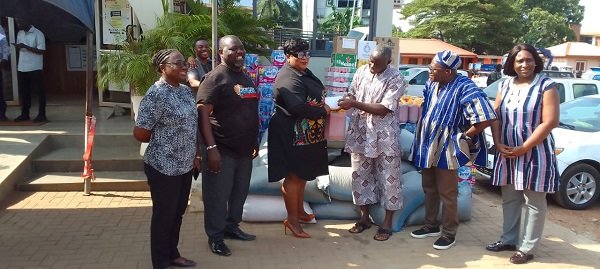 Ms Nongo (third from left) presenting the items to Nii Akpor