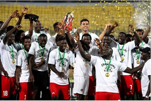 Asante Kotoko players celebrating with the Democracy Cup after beating Hearts on penalty shoot-outs