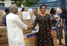 Ayawaso East Municipal---Mr Jamal presenting the items to one of the beneficiaries