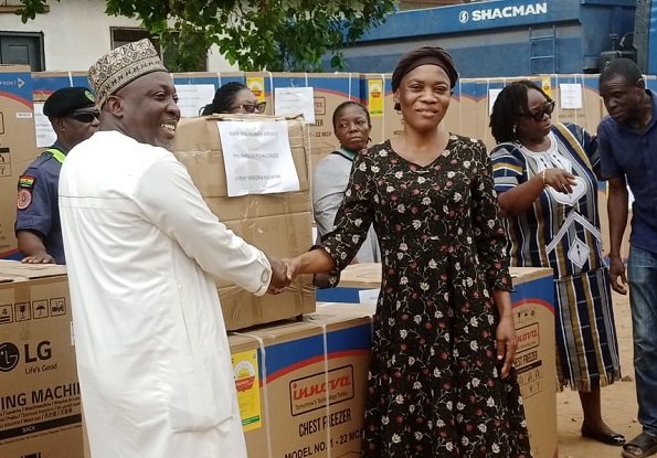 Ayawaso East Municipal---Mr Jamal presenting the items to one of the beneficiaries