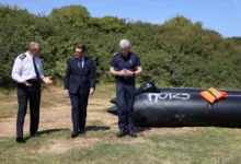 Britain’s Prime Minister Andy Burnham, centre, speaking with John Craig, Interim Chief Coastguard, and Duncan Capps, Border Security Commander (DG BSC), left