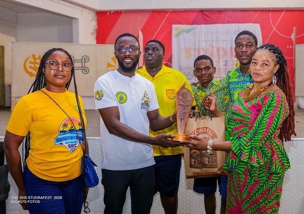 Dr Alhassan (right) presenting plaque to teachers and students of Pope John SHS