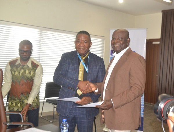 Mr Adjei (right) exchanging pleasantries with Mr Moukala after signing the MOU at the ceremony Photo Victor A. Buxton