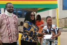Dr Lartey (middle) presenting a fund to a beneficiary