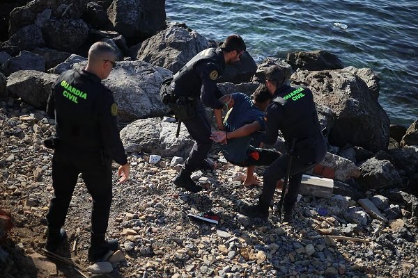 Members of the Spanish Guardia Civil (Civil Guard) detain a migrant