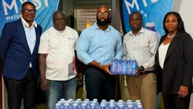 Mr Atitsogbui, Operations Manager at Medivents Consults receiving some of the water from the CEO of PNF Limited, producers of Myst Water