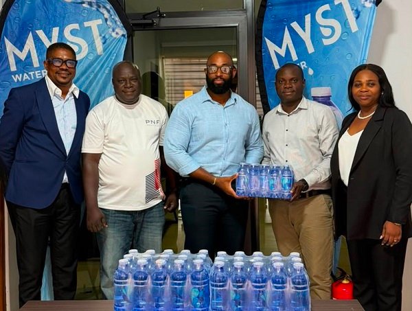 Mr Atitsogbui, Operations Manager at Medivents Consults receiving some of the water from the CEO of PNF Limited, producers of Myst Water