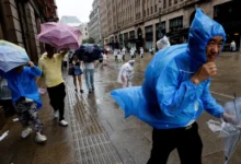 People use umbrellas and raincoats as winds intensify ahead of the arrival of Typhoon Dolphin in Shanghai, China