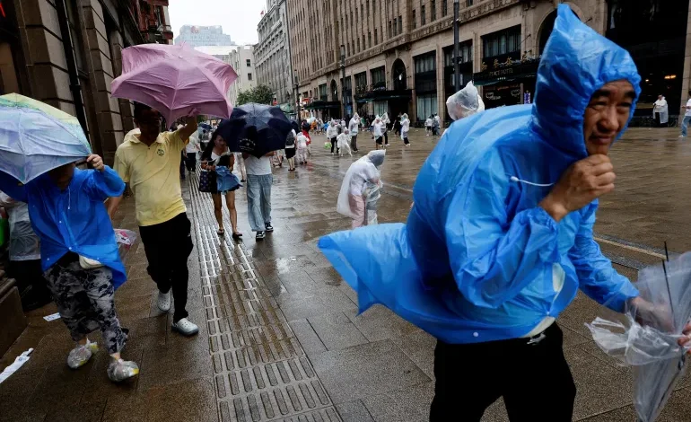 People use umbrellas and raincoats as winds intensify ahead of the arrival of Typhoon Dolphin in Shanghai, China