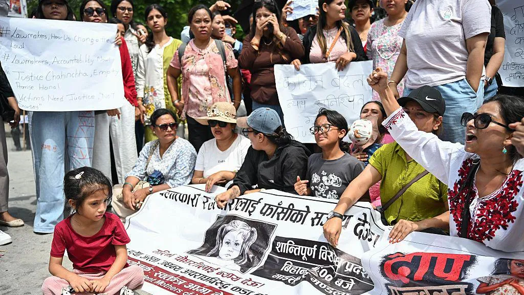 Protesters hold a banner showing the face of the child who was killed