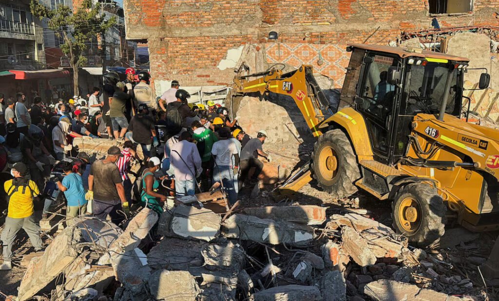 Residents and emergency personnel dig through the debris of a collapsed building following an earthquake, in Cali, Colombia 