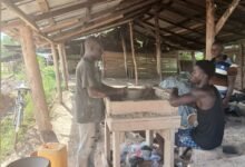 Abubakhar Alhassan (left) at his shop moulding earthenware at Tanoso