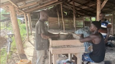 Abubakhar Alhassan (left) at his shop moulding earthenware at Tanoso